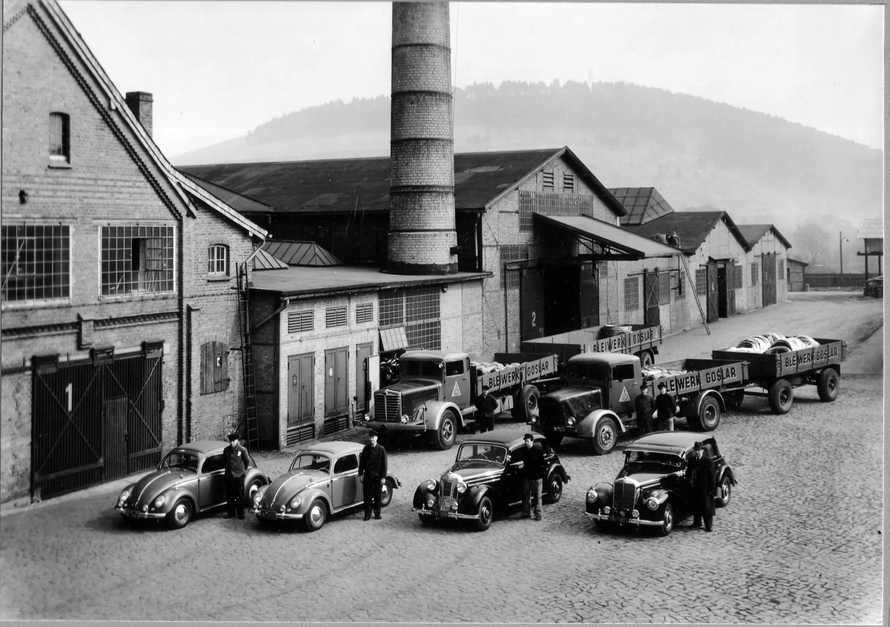 Historisches Foto des Werks in Goslar mit Lastwagen und Oldtimern